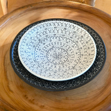 Decorative plate with geometric pattern on a wooden surface
