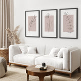 Modern living room with a white sofa, wooden coffee table, and Blush Pink Botanical Line Art Print Set of 3