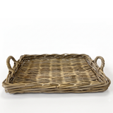 A rectangular woven wicker tray with two loop handles on the sides, shown on a plain white background.