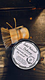 Solid natural dish soap with brush on a wooden surface