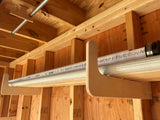 Metal conduit running along a wooden ceiling with visible text on the pipe.