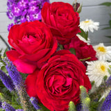 Bouquet of red Tiamo Roses with other flowers in the background