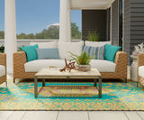 Outdoor patio with wicker furniture, cushions, and a colorful Turkish Aqua rug.