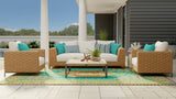Outdoor patio furniture set with wicker chairs and white cushions on a wooden deck. Turkish Aqua rug