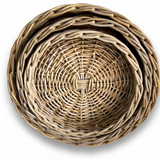 Three nested round woven baskets made from natural light brown wicker or rattan, shown from a top-down view on a white background.