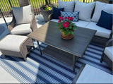 Outdoor patio set with a table, chairs, and a Vertical Stripe Blue & White rug on a patio.