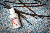 Bottle of Appalachian Goat Milk Lotion with vanilla beans on a textured blue and white surface