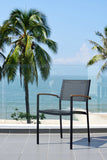 Stack of chairs with wooden armrests against a blurred green background