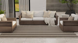 Outdoor patio furniture set with beige cushions on a patio with plants and a wall in the background.