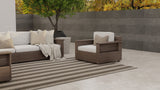Outdoor patio furniture set with cushions on a patio area.