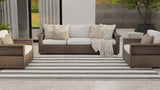 Outdoor patio furniture set with beige cushions on a striped rug.