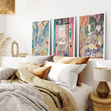 Bedroom with colorful Henri Matisse Abstract Painting Wall Art Prints on the wall, a bed with pillows, and a lamp.