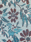 Close-up of a floral patterned Wildflowers Stone Terra fabric with blue and red colors.