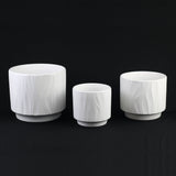 3-Piece White Stoneware Planter Pot Set with Embossed Texture of different sizes on a black background