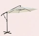Beige patio umbrella with a black stand on a light pink background