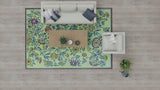Living room with a floral Wildflowers Eggplant rug, gray sofa, and wooden coffee table.