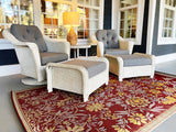 White wicker chairs with gray cushions on a red floral Wildflowers Cranberry rug in a living room.