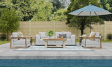 Outdoor patio set with furniture, Wildflowers Stone Terra rug, and umbrella by a pool
