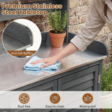 A stainless steel outdoor kitchen countertop with a dark gray cabinet base, shown in a real patio setting with a potted plant and a person wiping the surface with a cloth. Text highlights 'Premium Stainless Steel Tabletop' and features like 'Anti-fall Baffles,' 'Rust-free,' 'Easy-to-clean,' and 'Waterproof.