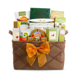 Gift basket with a brown woven design and gold bow, containing various food items on a white background.