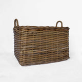A rectangular brown woven wicker basket with two loop handles, photographed on a plain white studio background.