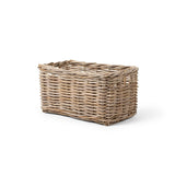 A rectangular woven wicker basket with a natural light brown color, shown from a three-quarters perspective on a clean white background.