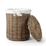 Wicker laundry basket with a white liner on a white background