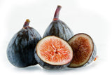 Dwarf Fig Tree "Beer's Black" with one cut open to reveal pinkish flesh on a white background