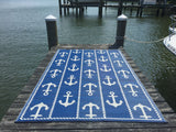 Blue rug with white anchor pattern on a dock by water