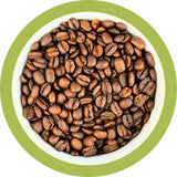 Coffee beans in a white bowl with a green rim on a white background