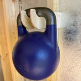 Blue kettlebell on a wooden surface with a textured wall background