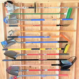 A collection of various hand tools, including shovels, spades, a string trimmer, and a brush cutter, neatly arranged in a wooden storage rack.