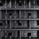 Stack of black plastic trays with multiple compartments on a black background