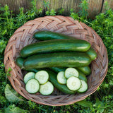 Basket of Green Finger Cucumbers (Organic) and sliced cucumbers on a green leafy background