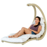 Woman sitting in a hanging chair with white cushions on a white background
