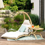 Modern outdoor lounge chair with cushions and a small table on a wooden deck.