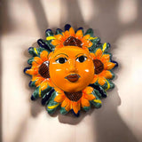 Decorative sun-shaped wall art with floral details on a plain background