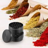 Black spice grinder with various dried spices in paper cones on a white surface
