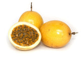 Passion fruit with one cut open to reveal seeds on a white background