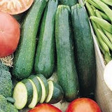 Organic Heirloom Dark Green Zucchini and green beans on a wooden surface.