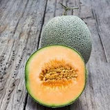 Halved Heirloom Organic Edisto Cantaloupe on a wooden surface