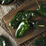 Green Heirloom Organic Ancho 101 Hot Peppers on a wooden cutting board