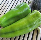 Two Organic Heirloom Cubanelle/ Sweet Fryer Peppers on a woven mat