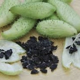 Sliced Rare Organic Heirloom Caigua Seedswith black seeds on a wooden surface