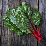 Bunch of Organic Heirloom Ruby Red Swiss Chard on a wooden surface