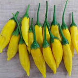 Yellow peppers with green stems on a wooden surface