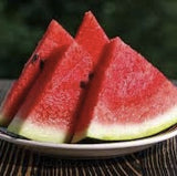 Three slices of Organic Heirloom Jubilee Watermelon on a plate with a blurred background