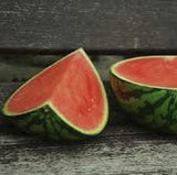 Two halves of a Organic Heirloom AU Producer Watermelon on a wooden surface