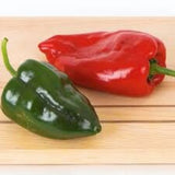 Two Heirloom Organic Ancho 101 Hot Peppers, one green and one red, on a wooden surface.