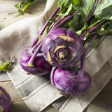 Heirloom Organic Azur Star Kohlrabi on a wooden surface with a cloth napkin